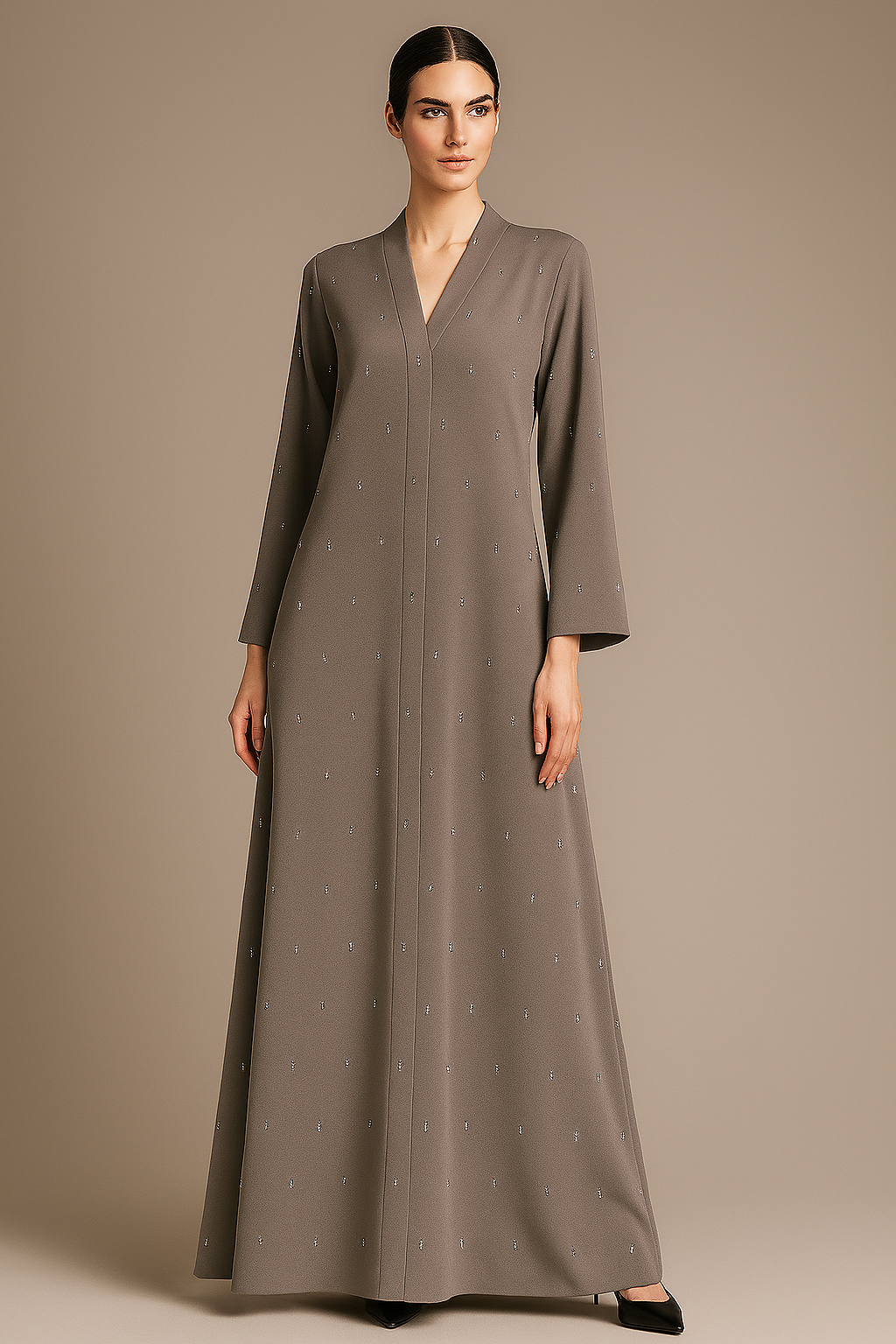 Woman wearing a long gray abaya against a beige background